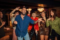 A medium close up of a man who out with his friends in a nightclub in Newcastle upon Tyne in the North East of England. He is dancing and having a carefree time with good friends and letting himself go and having a jolly old time celebrating for New Years eve.