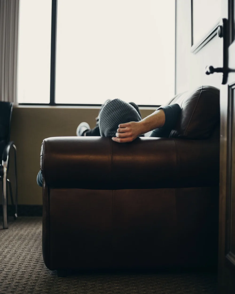 man with beanie relaxing on couch