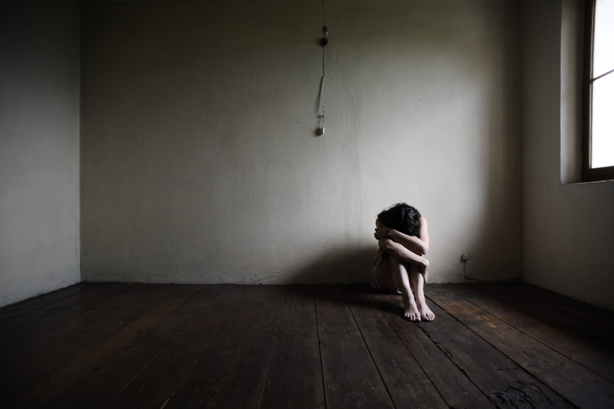 sad woman sitting alone in a empty room