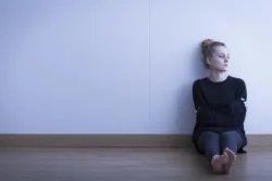 teenager woman sitting against wall