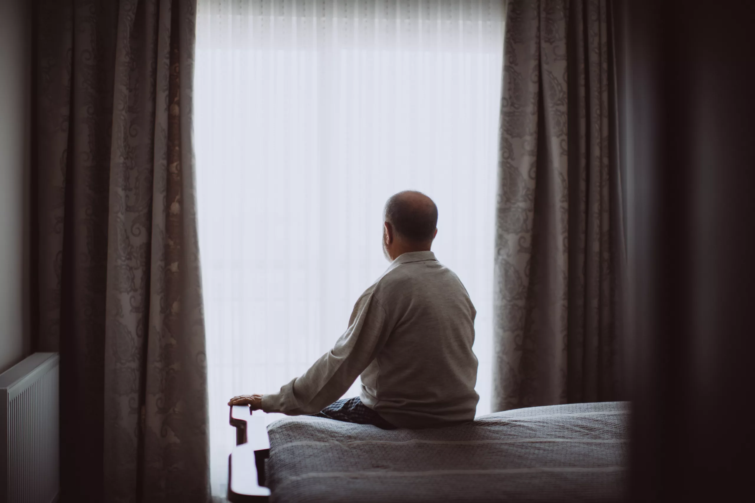Growing old isn't for sissies. Shot of a depressed senior man sitting on his bed at home