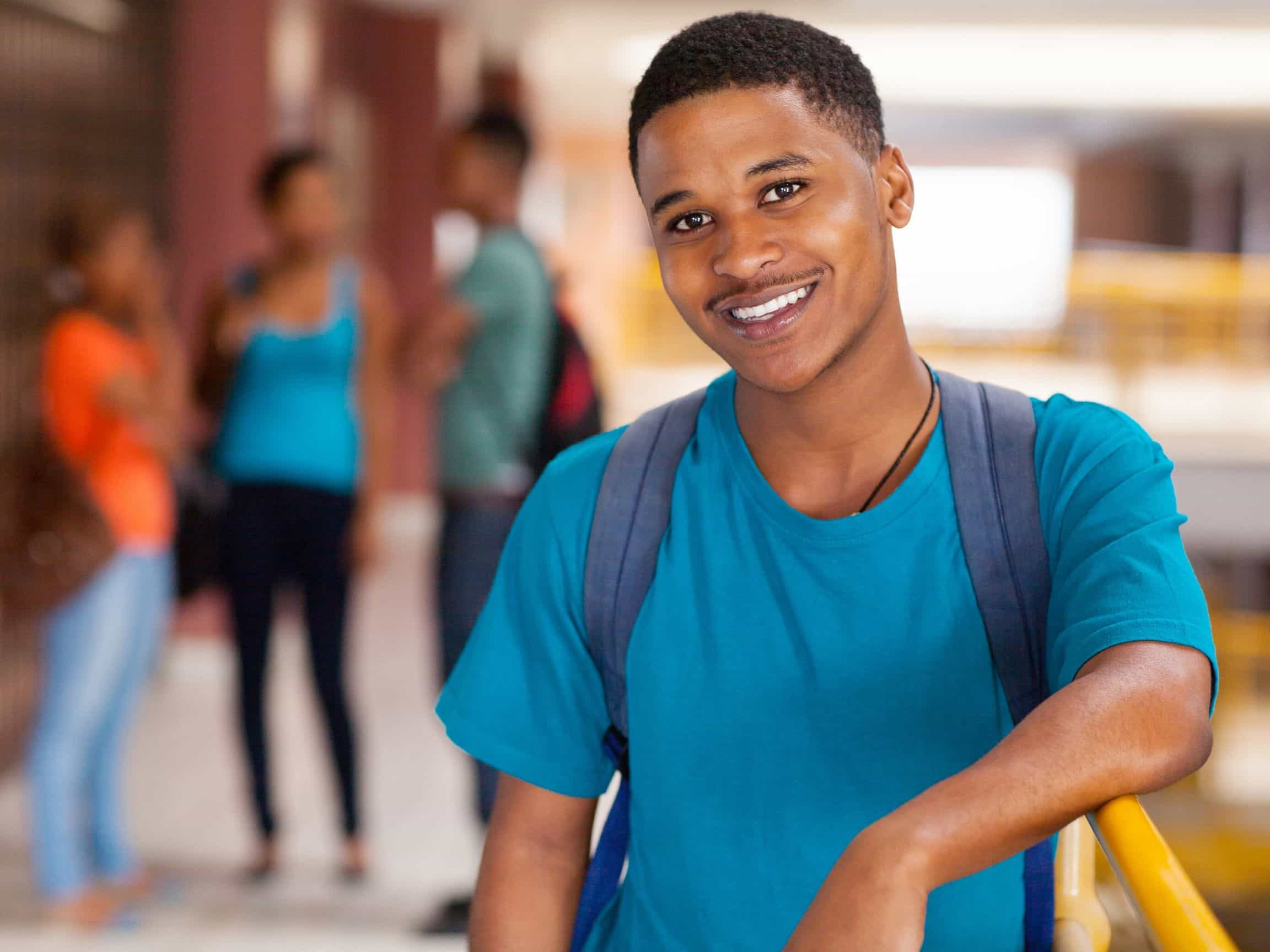 A male college student wearing a blue backpack