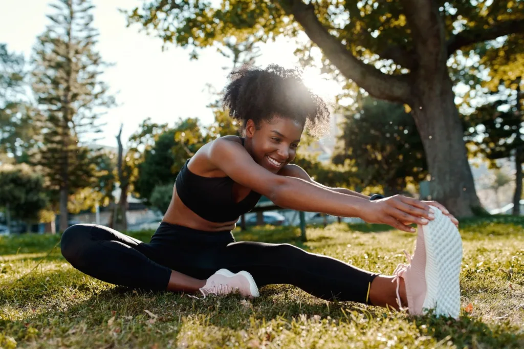 Black female stretching in the park before going on a run