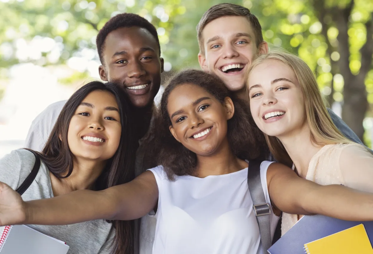 Multiracial group of teenage friends smiling for the camera