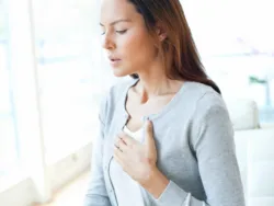 A woman puts a hand to her chest as she experiences a panic attack