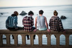 friends sitting on edge of water