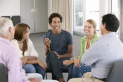 patient experience Smiling people sitting around in a circle talking