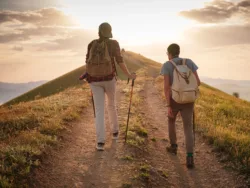 a-couple-of-happy-young-hikers-backpacking-on-a-beautiful-rocky-trail-on-a-warm-sunset-evening-the-concept-of-family-travel-and-adventure-view-from-behind-travel-lifestyle-stockpack-istock A couple of happy young hikers backpacking on a beautiful rocky trail on a warm, sunset evening. The concept of family travel and adventure. view from behind. Travel lifestyle.