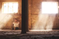 Addiction-is-Disease man sitting alone with bottle of alcohol
