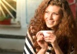 Staying Mentally Well A smiling woman with curly brown hair holds a coffee mug