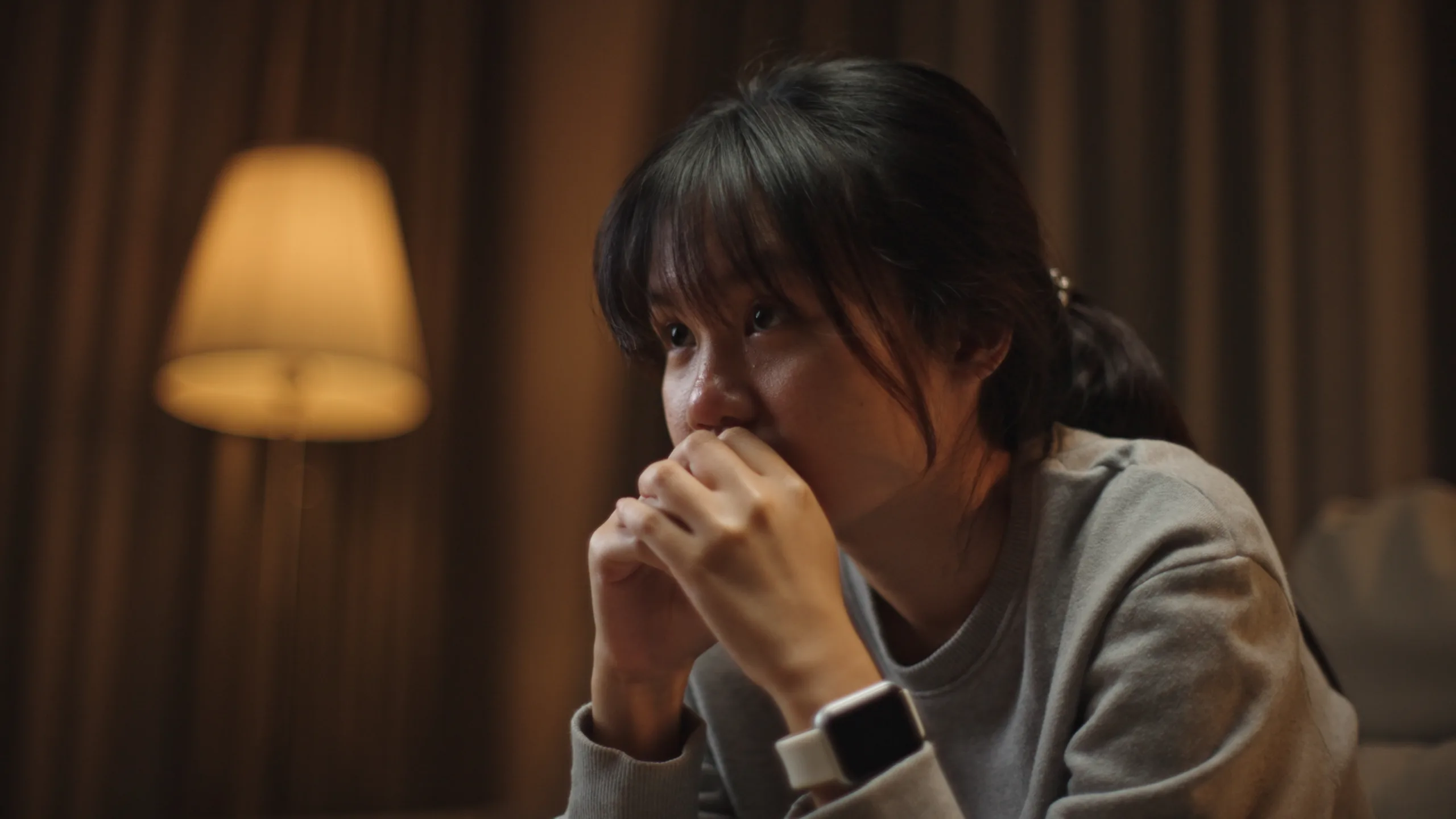 Asian young woman stressing alone on sofa at night.