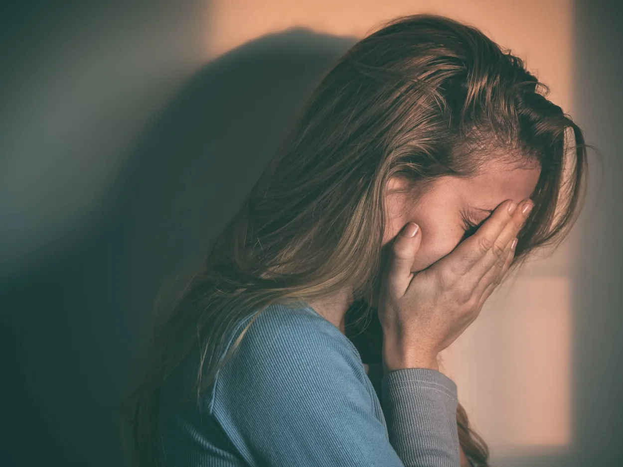 Sad woman with her head in her hands