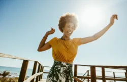 excited-young-woman-running-on-a-boardwalk-with-her-hands-raised-on-a-sunny-day-african-female-having-fun-on-summer-vacation-at-the-seaside-stockpack-istock Excited young woman running on a boardwalk with her hands raised on a sunny day. African female having fun on summer vacation at the seaside.