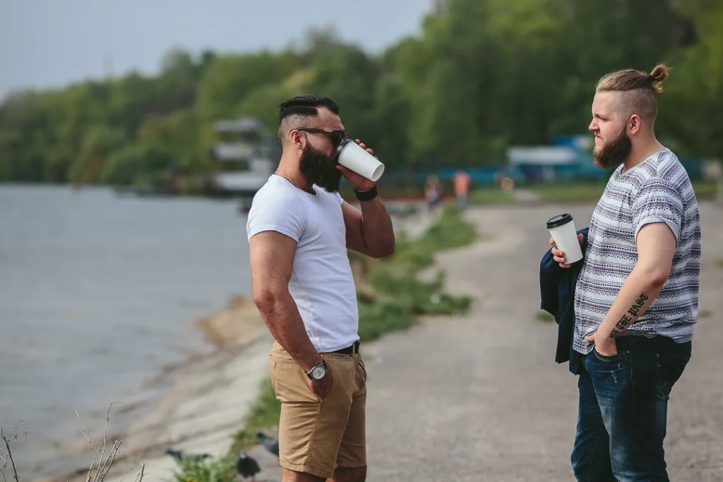 friends drinking coffee near water