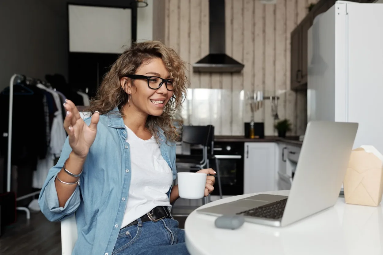 Adult female on a video call during the morning with a mug of coffee in her hand