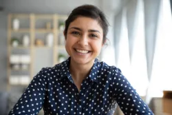 Happy young indian woman blogger applicant teacher sit at home office look at camera doing online job interview during video chat conference call record vlog teaching on webinar in app, webcam view