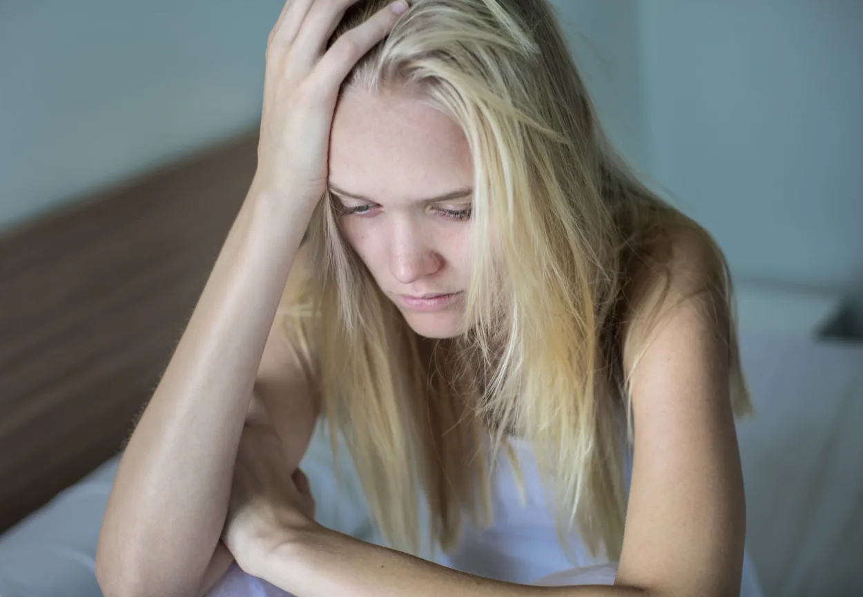 A woman alone crying in bed, worried in misery.