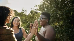 laughing-woman-and-a-group-of-other-women-standing-with-her-hands-together-during-an-exercise-at-a-wellness-retreat-in-summer-stockpack-gettyimages Laughing woman and a group of other women standing with her hands together during an exercise at a wellness retreat in summer