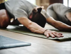 man-yoga-and-class-in-exercise-workout-or-fitness-for-stretching-health-and-wellness-in-childs-pose-at-gym-yogi-group-with-coach-in-warm-up-body-stretch-or-session-for-indoor-pilates-or-lesson-stockpack-gettyimages Man, yoga and class in exercise, workout or fitness for stretching, health and wellness in childs pose at gym. Yogi group with coach in warm up, body stretch or session for indoor pilates or lesson