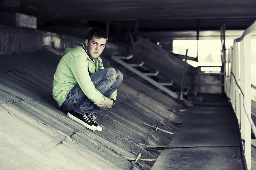 man sitting by himself in tunnel