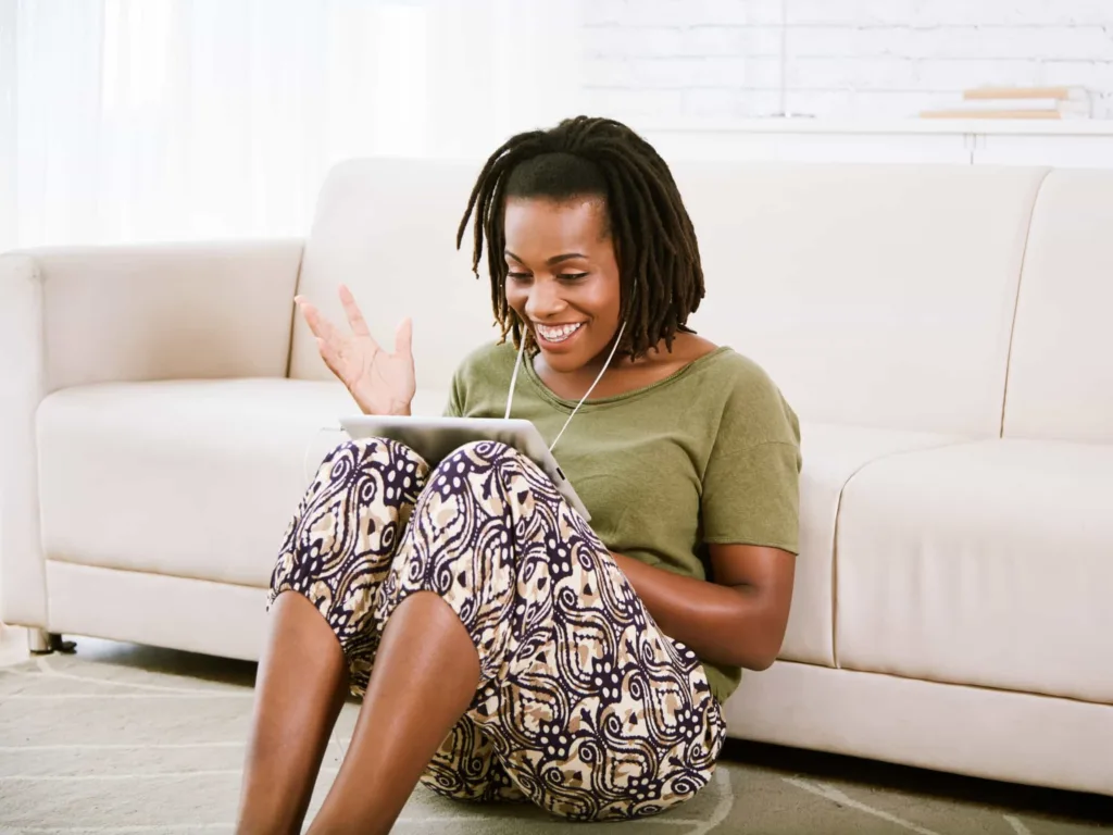 A woman participates in an online therapy session on her tablet