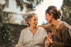 Daughter sitting with elderly mother in the mother having a cheerful conversation