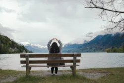 Self Compassion woman sitting on bench by lake