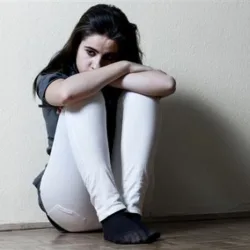teenager curled up in corner
