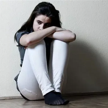 teenager curled up in corner