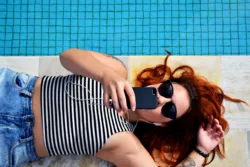 woman listening to music by pool