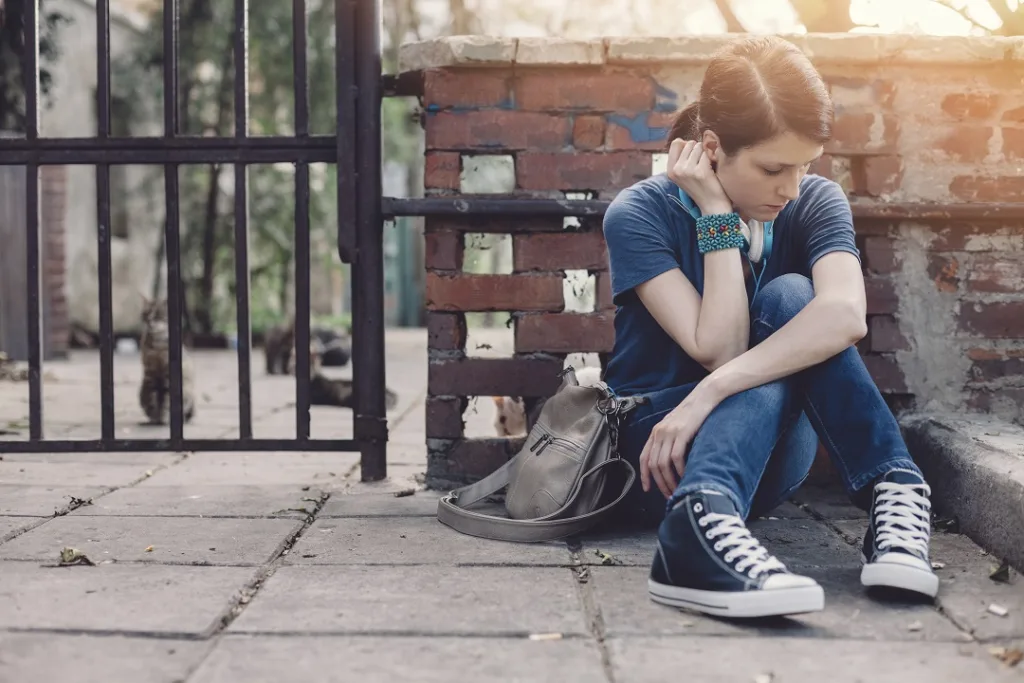 teenager with headphones sitting alone