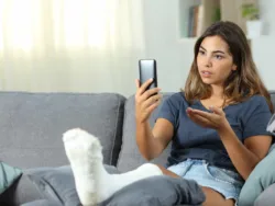 Telemental Health FAQs A woman talks to her therapist over the phone in a teletherapy session