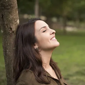 woman leaning against tree
