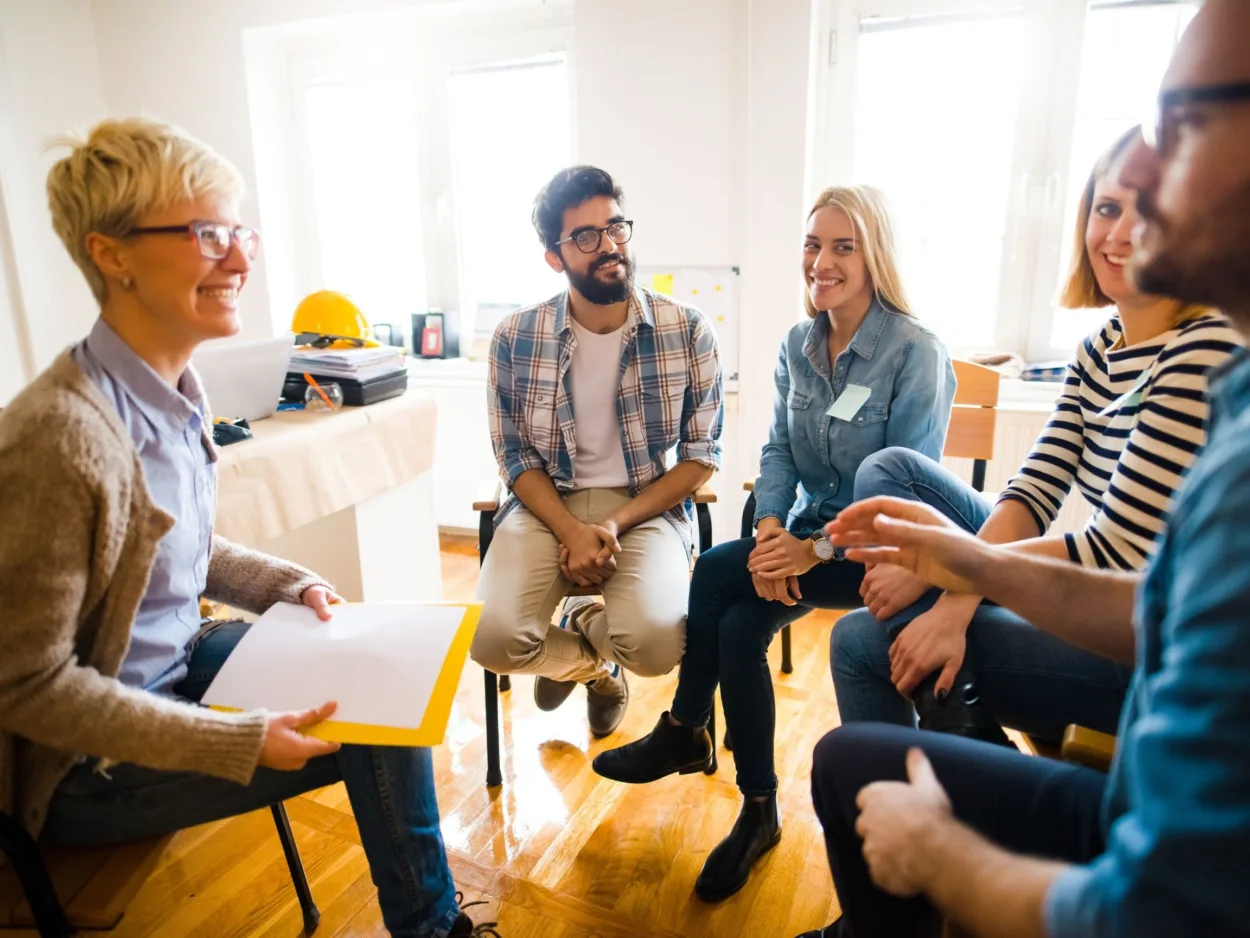 Five people sit in a circle for a group addiction counseling session