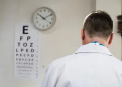 Talk-to-Doctor-About-Addiction doctor in office with vision chart on wall