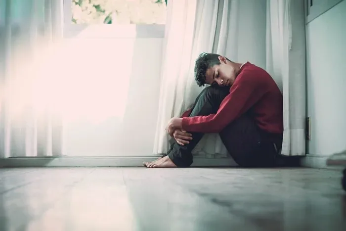 man sitting by himself in corner
