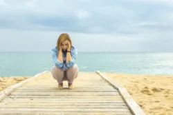 A woman suffering from PTSD crouches down on the ground in fear