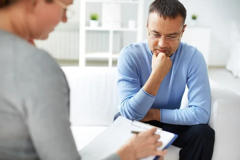 man speaking with therapist